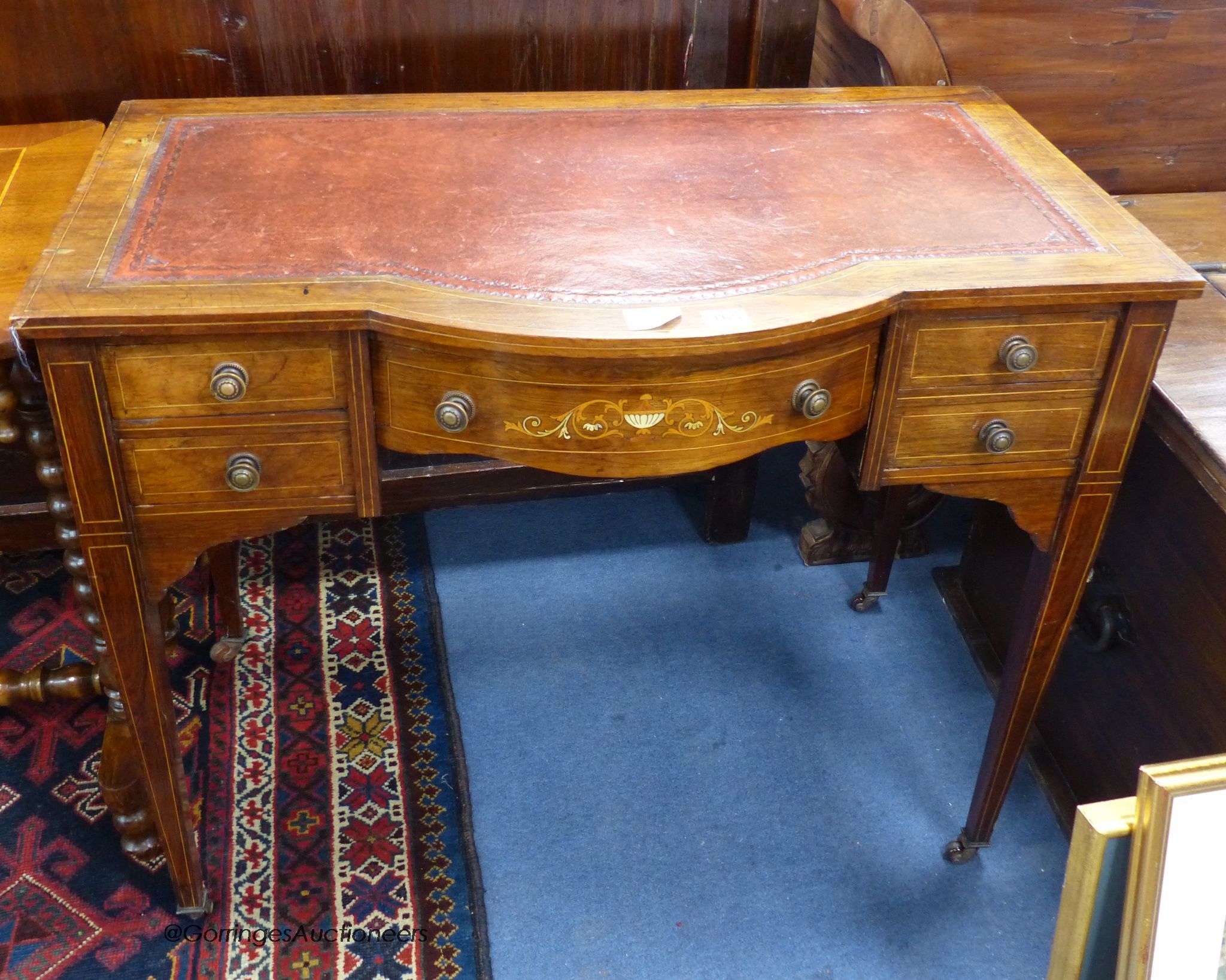 A Edwardian inlaid rosewood bow front writing table, width 88cm, depth 51cm, height 71cm